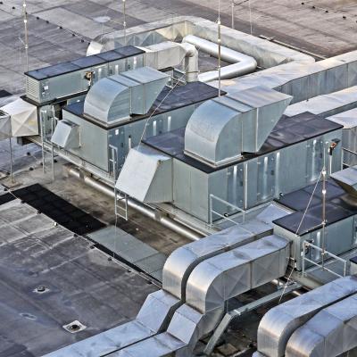 Luftaufnahme von komplexen mechanischen Dachinstallationen mit Lüftungsrohren und Klimageräten.