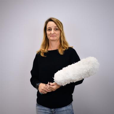 Porträt von Raumpflegerin Nicole Graf mit Staubwedel