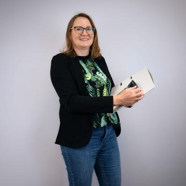 Porträt von Buchhalterin Nicole Kronberger mit Ordner