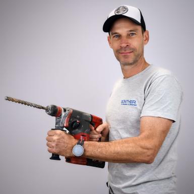 Porträt von Techniker Roland Sonnleitner mit Bohrhammer