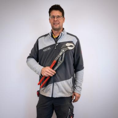 Porträt von Fachmonteur Christoph Stöger mit Rohrzange